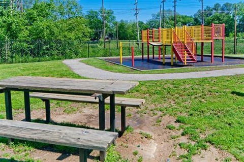 two picnic tables in front of a playground